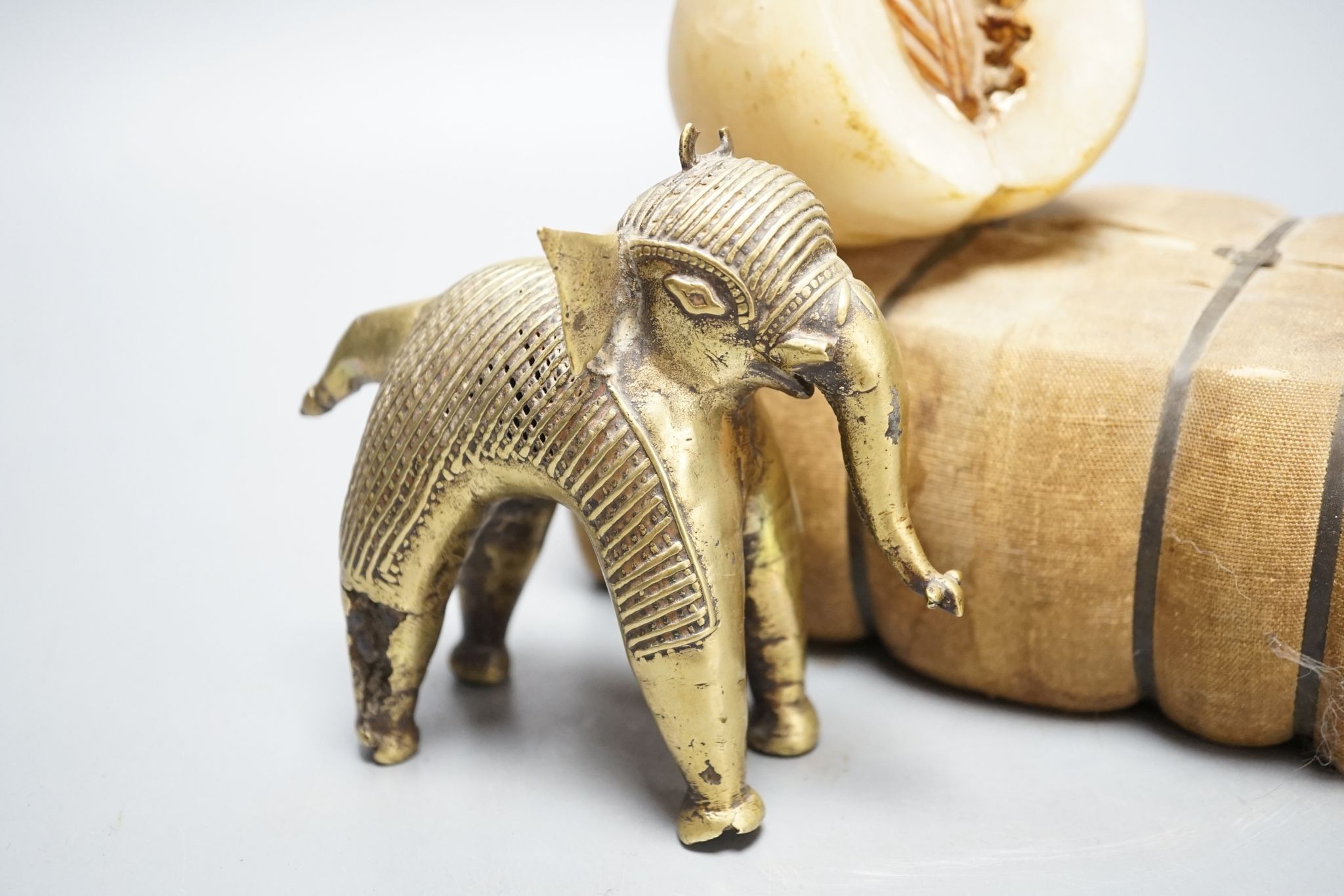 An alabaster fruit carving, a Benin brass elephant and salesman's model of a bale of Drysdale cotton, 18 cm